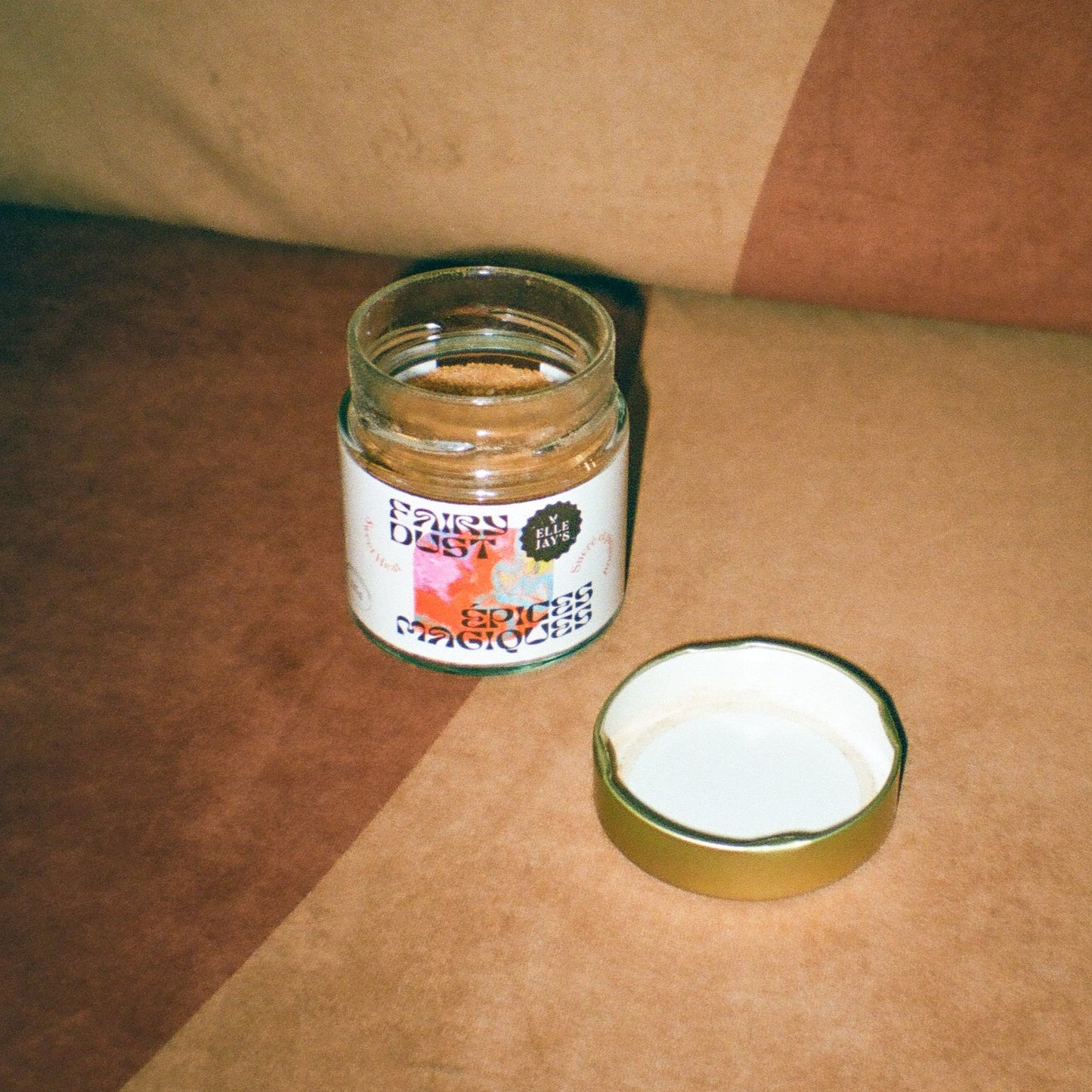 Open Fairy Dust Sweet Heat Spice jar on retro chair